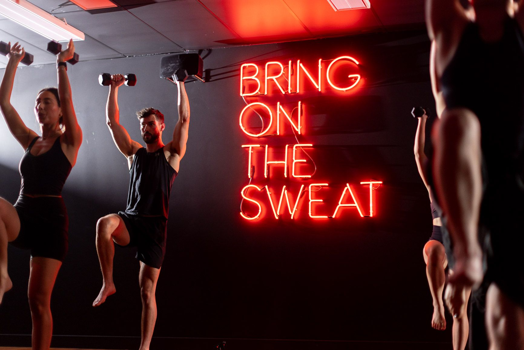 Man And Woming In Gym Outfit With A Neon Text Bring On The Sweat Man And Woming In Gym Outfit With A Neon Text Bring On The Sweat